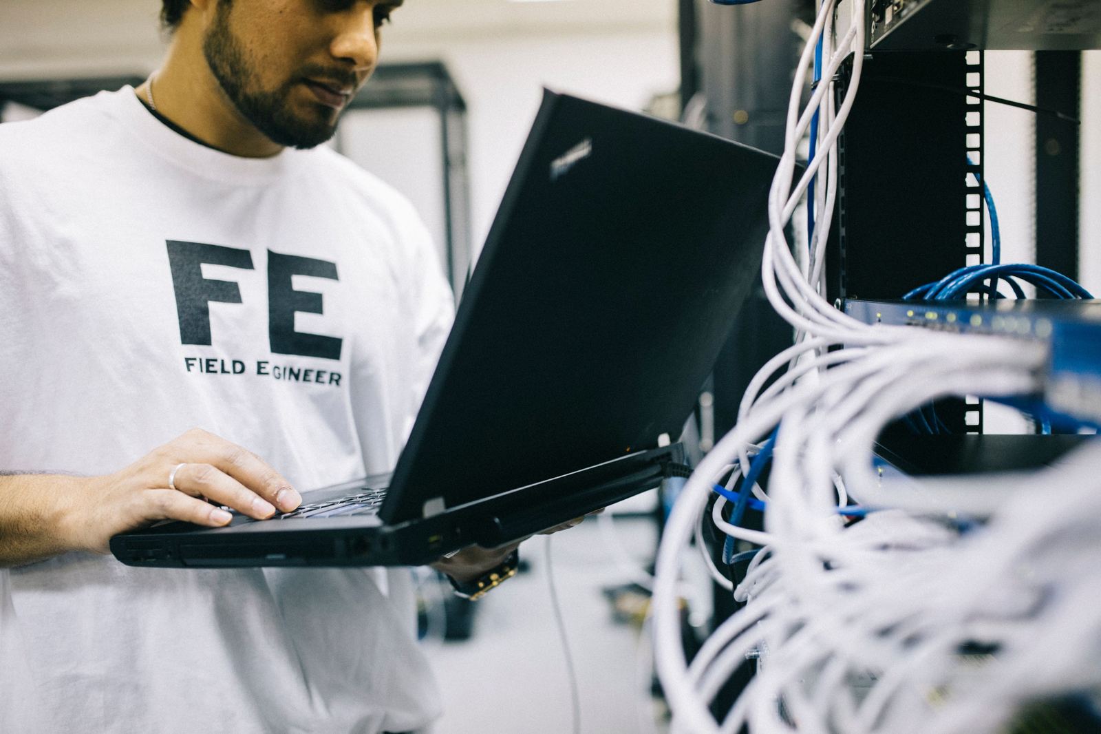 Engineer working on network equipment in a rack